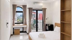 A modern hotel room with a bed, a desk, a wardrobe, and a balcony with curtains. - Dreamora Serenity Hotel & Residence (Hanoi)