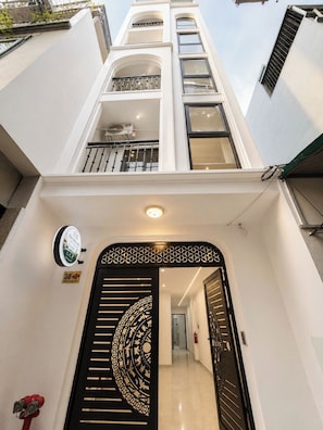 Un edificio moderno con una escalera central, una reja negra decorativa y un extintor.