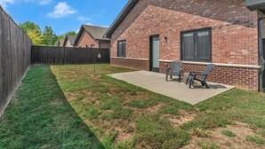 A residential backyard with a patio, two chairs, and a wooden fence. - Comfort, Space & Convenience – Beautiful 3-Bedroom (Hendersonville)