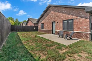 A residential backyard with a patio, two chairs, and a wooden fence. - Comfort, Space & Convenience – Beautiful 3-Bedroom (Hendersonville)