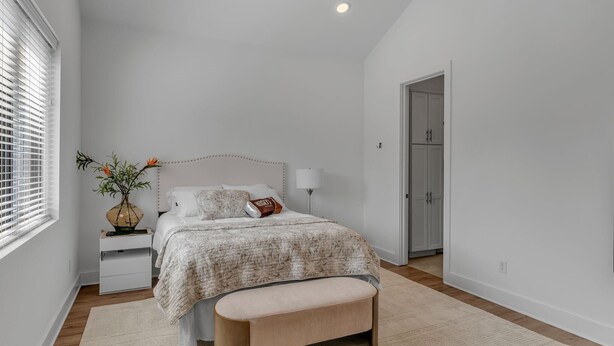 A bedroom with a bed, bedside table, lamp, and a window with blinds. - Comfort, Space & Convenience – Beautiful 3-Bedroom (Hendersonville)