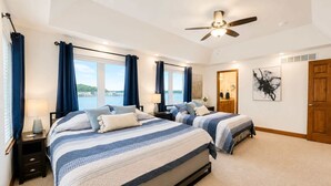 A bedroom with two beds, a ceiling fan, and a view of the water. - It's A Shore Thing - Boat Slips and Hot Tub (Osage Beach)