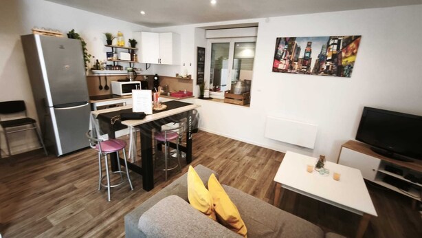 A compact living space with a kitchenette, a dining area, a sofa with cushions, and a television. - House les acacias - 6 people (Mauléon)