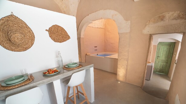 Una cocina moderna con barra, un arco de piedra y una bañera.