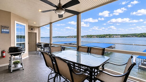 Un comedor con vista a un lago, un ventilador de techo y un cartel en la pared.
