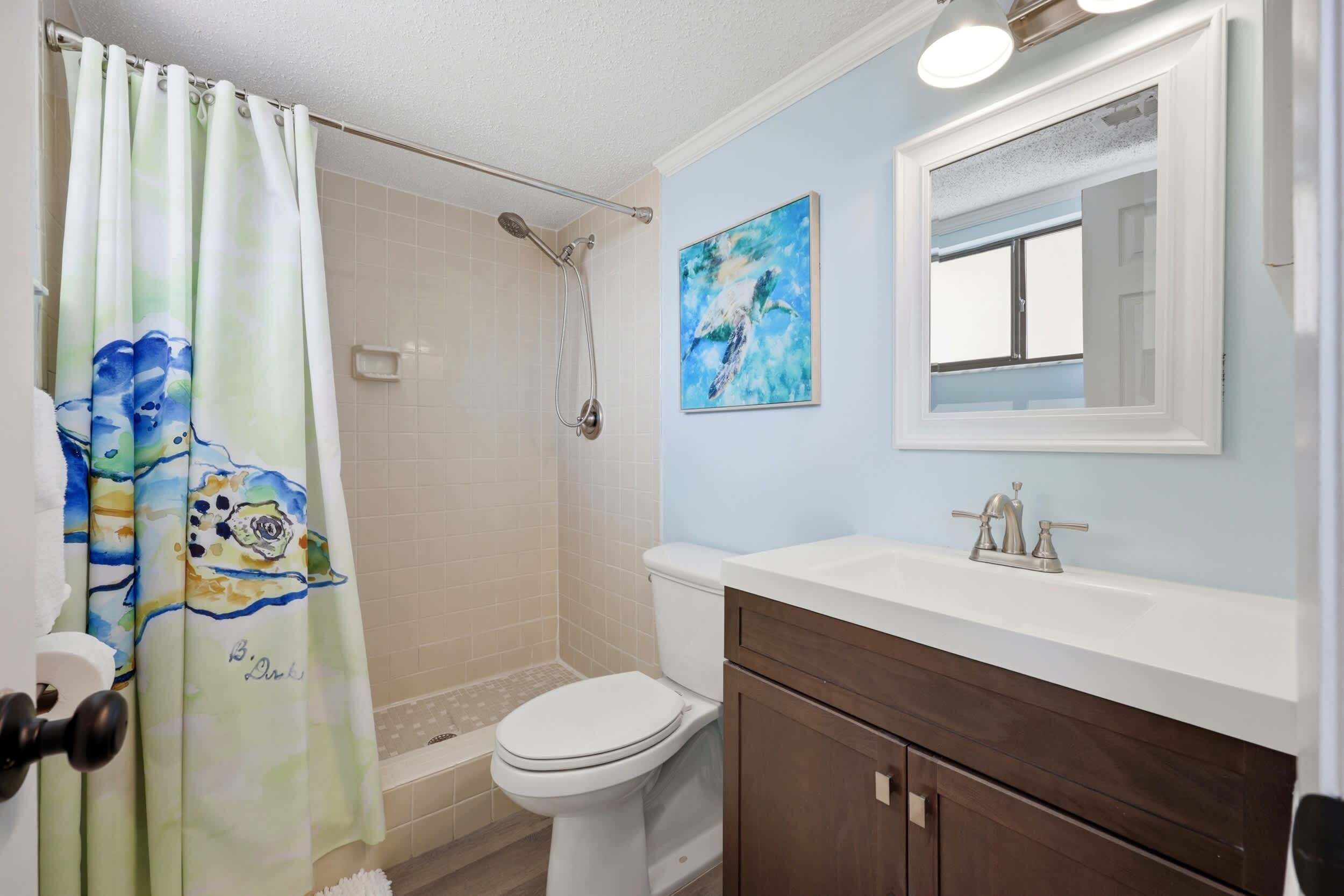A bathroom with a shower, toilet, and sink.