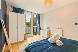 A bedroom with a bed, a wardrobe, a dresser, a radiator, and a view of the outdoors. - Welcome to "your space" with Private Patio (Birmingham)