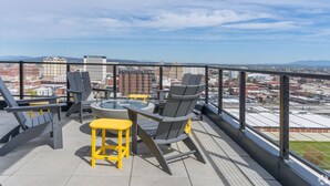 A rooftop terrace with outdoor seating, a hot tub, and a city view. - 8th Floor Studio Rental with High Ceilings! (Spokane)