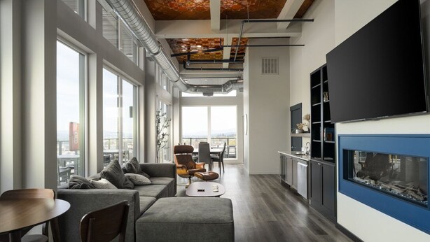 A modern living room with a large TV, seating area, and a fireplace. - 8th Floor Studio Rental with High Ceilings! (Spokane)