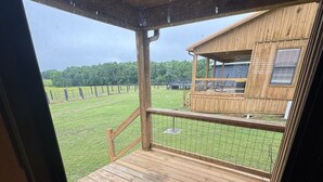 Un ponte di legno con ringhiera, vista su una proprietà recintata e un edificio con finestre.