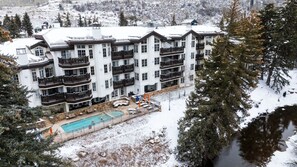 A multi-story hotel with balconies, a swimming pool, and a view of snowy mountains. - Upscale PH @Austria Haus in Vail Village on Bridge Rd, 3 min walk to Gondola 1 (Vail)