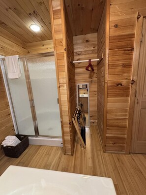 A wooden cabin interior with a shower, a small mirror, and a wooden bench. - Cabin 6 at Lamb Ranch (Michie)