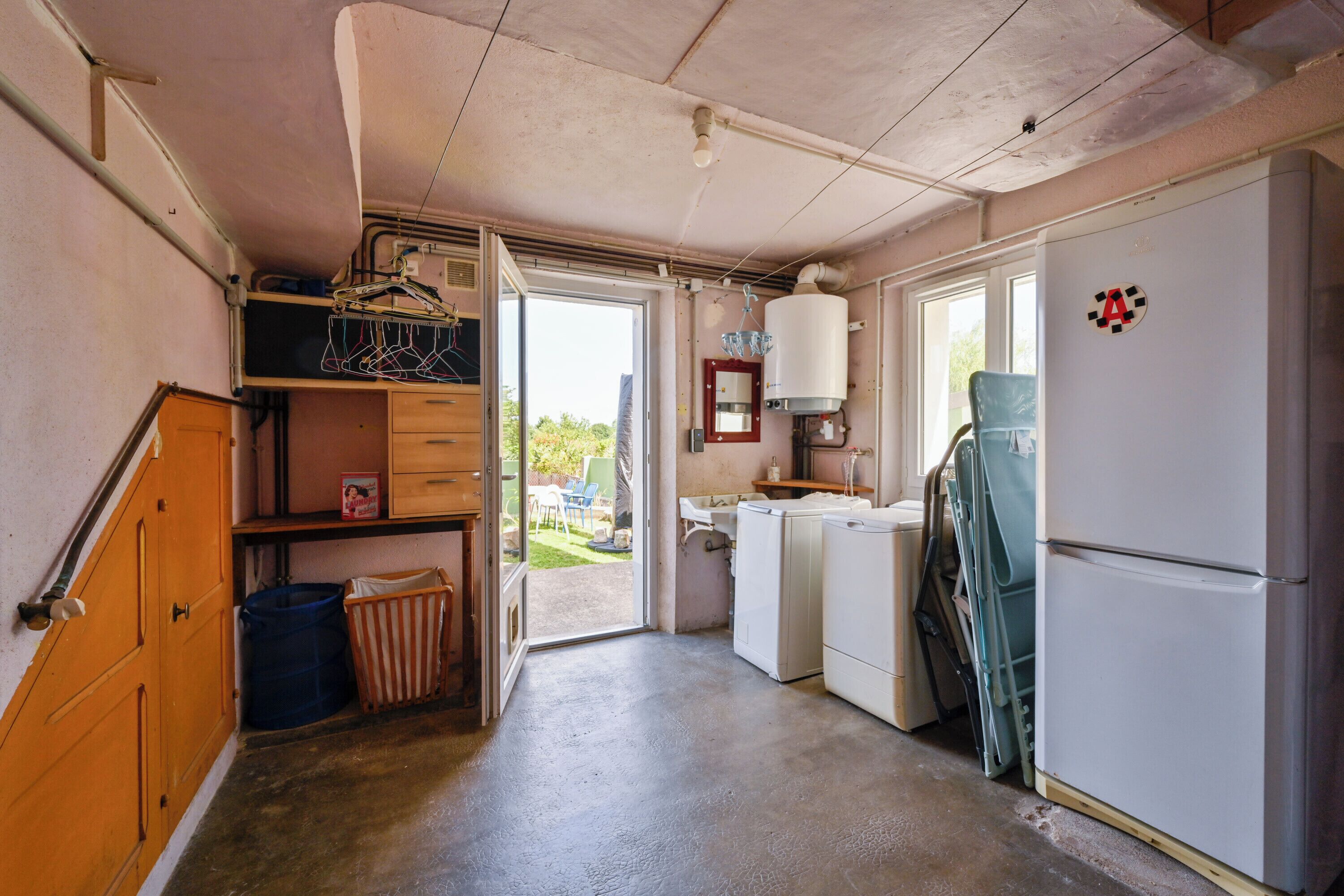 A compact kitchen with a refrigerator, washing machine, and a sink.