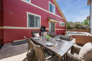 A red house with a patio, outdoor furniture, and a grill. - Old Town North Retreat Bikes, Brews & Trails (Fort Collins)