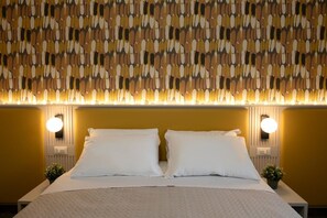 Ein Hotelzimmer mit einem Bett, zwei Nachttischlampen und einer Wand mit Muster.