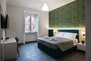 Ein modernes Hotelzimmer mit Bett, Nachttischen, einem Schreibtisch und einem großen Fenster.