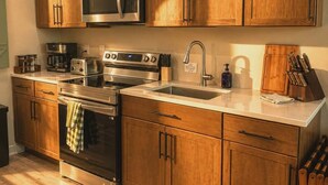 A modern kitchen with wooden cabinets, stainless steel appliances, and a built-in oven.