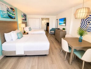 A hotel room with a bed, bedside tables, a desk, and chairs. - Charming Oceanfront Studio for 4! Pinnacle 1163 (Myrtle Beach)