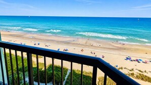 A beach with clear skies, a sandy shore, and a railing in the foreground. - Charming Oceanfront Studio for 4! Pinnacle 1163 (Myrtle Beach)