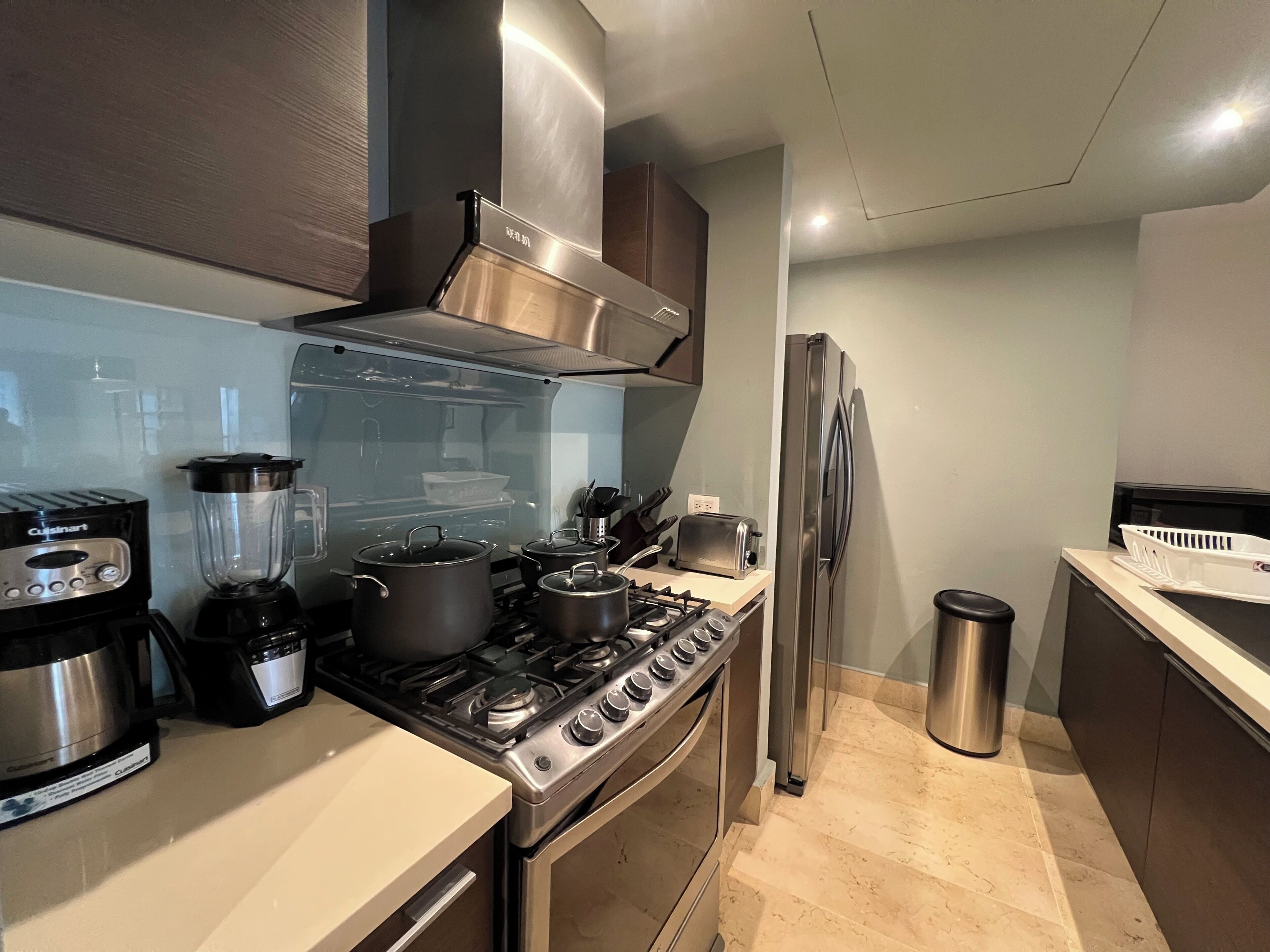 Een moderne keuken met roestvrijstalen apparatuur, een gasfornuis, een inbouwoven, een koelkast en een vaatwasser.