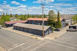 A street view with a building that has a red roof and a flag on the side. - The Wildflower (West Yellowstone)