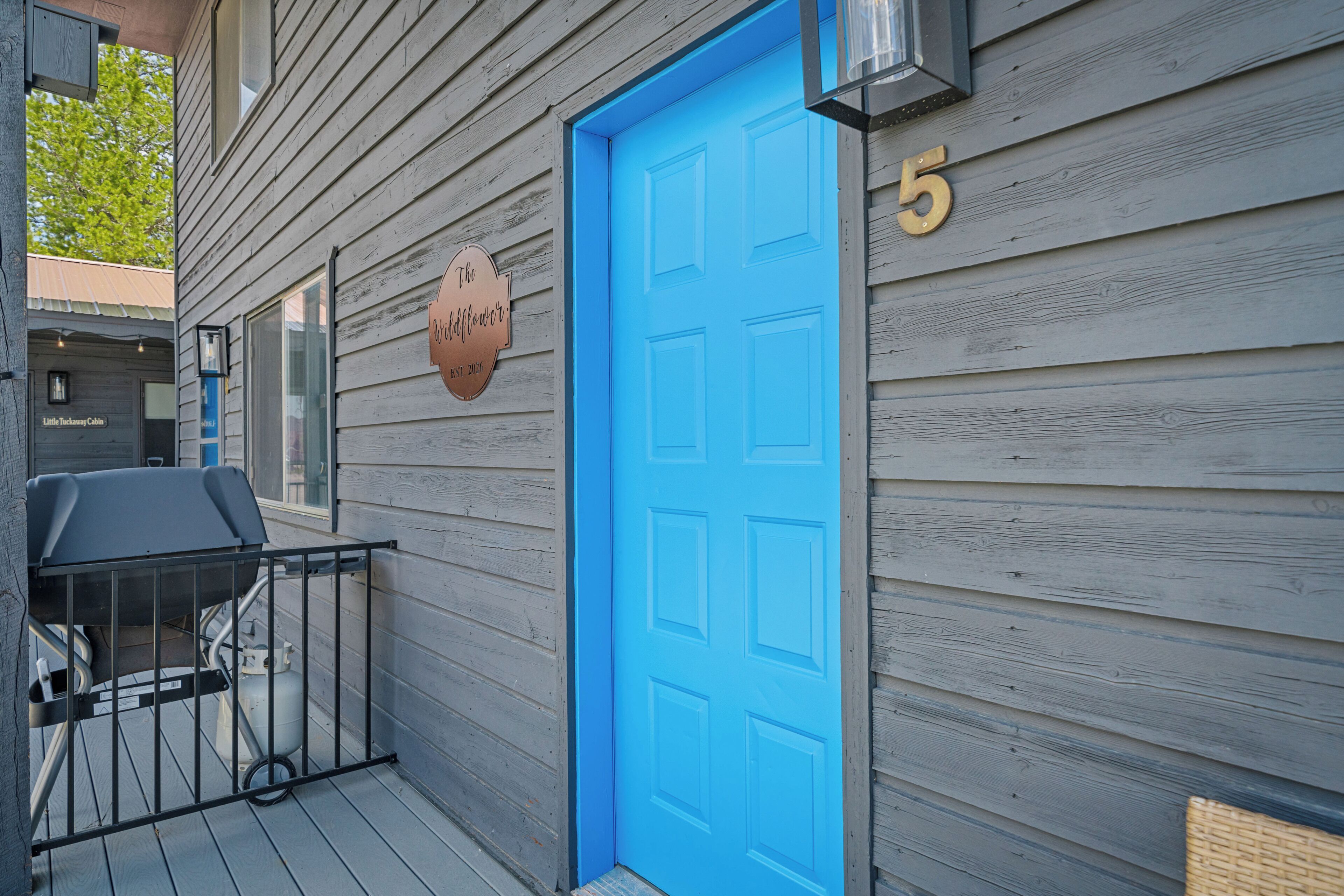 A wooden building with a blue door and a number '5' sign.