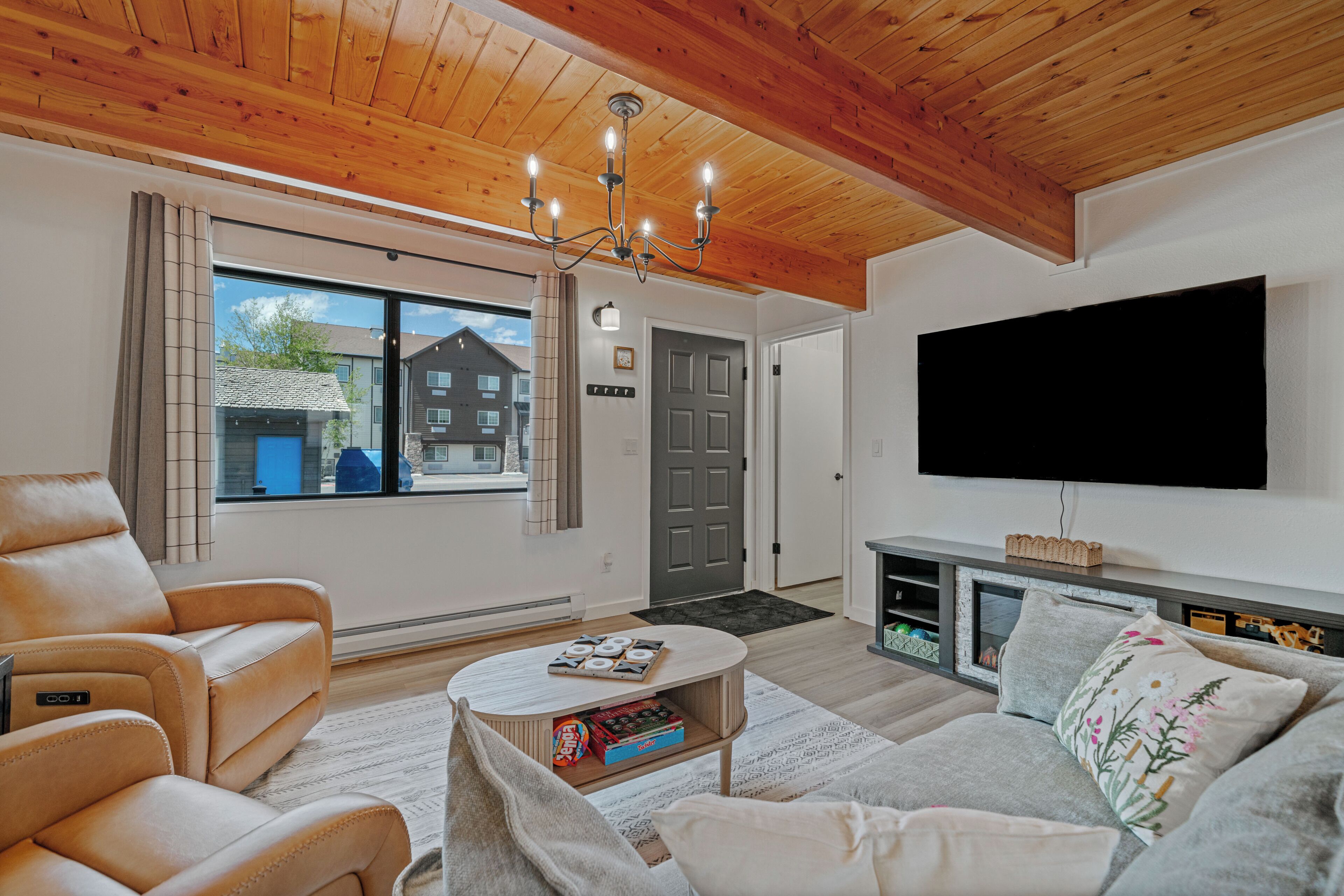 A modern living room with a sofa, a coffee table, a TV, and a fireplace.