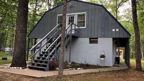 Uma cabana com escadas, janela e porta.
