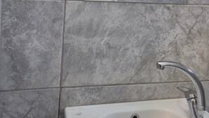 Un baño con lavamanos blanco, secador de pelo y espejo.