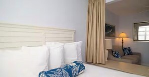 Habitació d'hotel amb llit, sofà, làmpada i mirall.