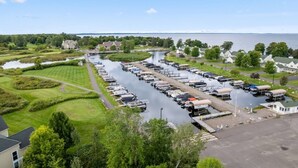 A marina with boats docked, a river, and houses in the background. - The Villages @Izatys Cabin Week 45 (Onamia)
