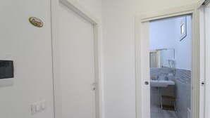 A white door with a light switch and a small decorative plate.