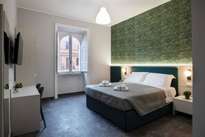 Ein Schlafzimmer mit Bett, Nachttischen, Schreibtisch, Stuhl, Fenster und einer Wand mit Struktur.