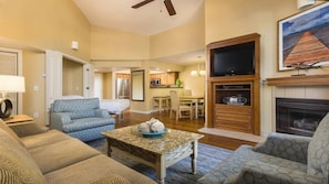 A living room with a sofa, a coffee table, a TV, and a fireplace. - Mountain & Lake Vacation with Spacious 2BR at South Shore (Zephyr Cove)