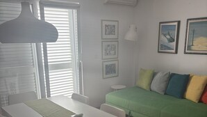 A room with a dining table, chairs, a green sofa, and a small round table. - Elegant penthouse apartment with a view of the sea and two terraces in Rovinj (Rovinj)