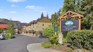 A resort sign, a row of buildings, and a parking area. - Collins Lake Mountain Condo #24| Pool, Sauna & Spa (Government Camp)
