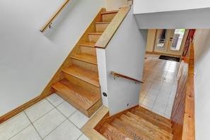 Eine Treppe mit Holzboden und Handlauf, die zu einer Tür mit Fensterglas führt.
