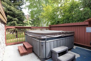 Ein Whirlpool mit Holzterrasse, einer Bank und einem Schild an der Wand.