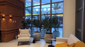 Una sala de estar moderna con un ventanal grande, un sofá, una mesa de centro y una pared de ladrillo decorativa.