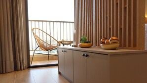 Una cocina moderna con un armario de madera, una silla de mimbre y un cuenco con objetos decorativos sobre la encimera.