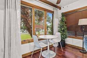 A room with a round table and two chairs, a potted plant, a lamp, and a window with blinds. - "Chalet" lake house/walking path/fenced yard/dock (Winter Haven)