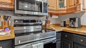 A kitchen with a stainless steel range, microwave, oven, and toaster.