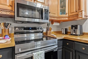 A kitchen with a stainless steel range, microwave, oven, and toaster.