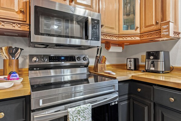 A kitchen with a stainless steel range, microwave, oven, and toaster.
