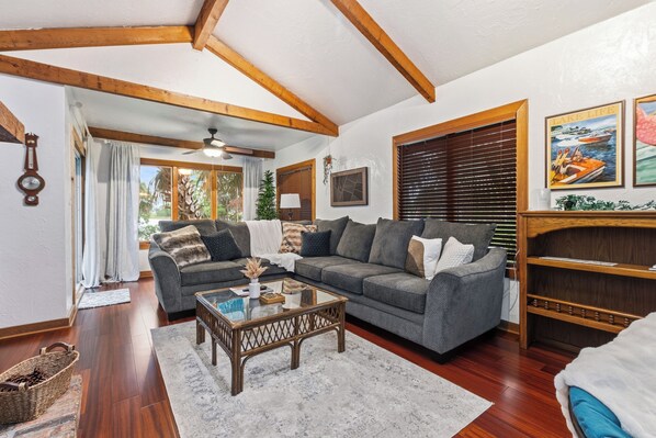 A living room with a sofa, coffee table, and wooden beams on the ceiling.