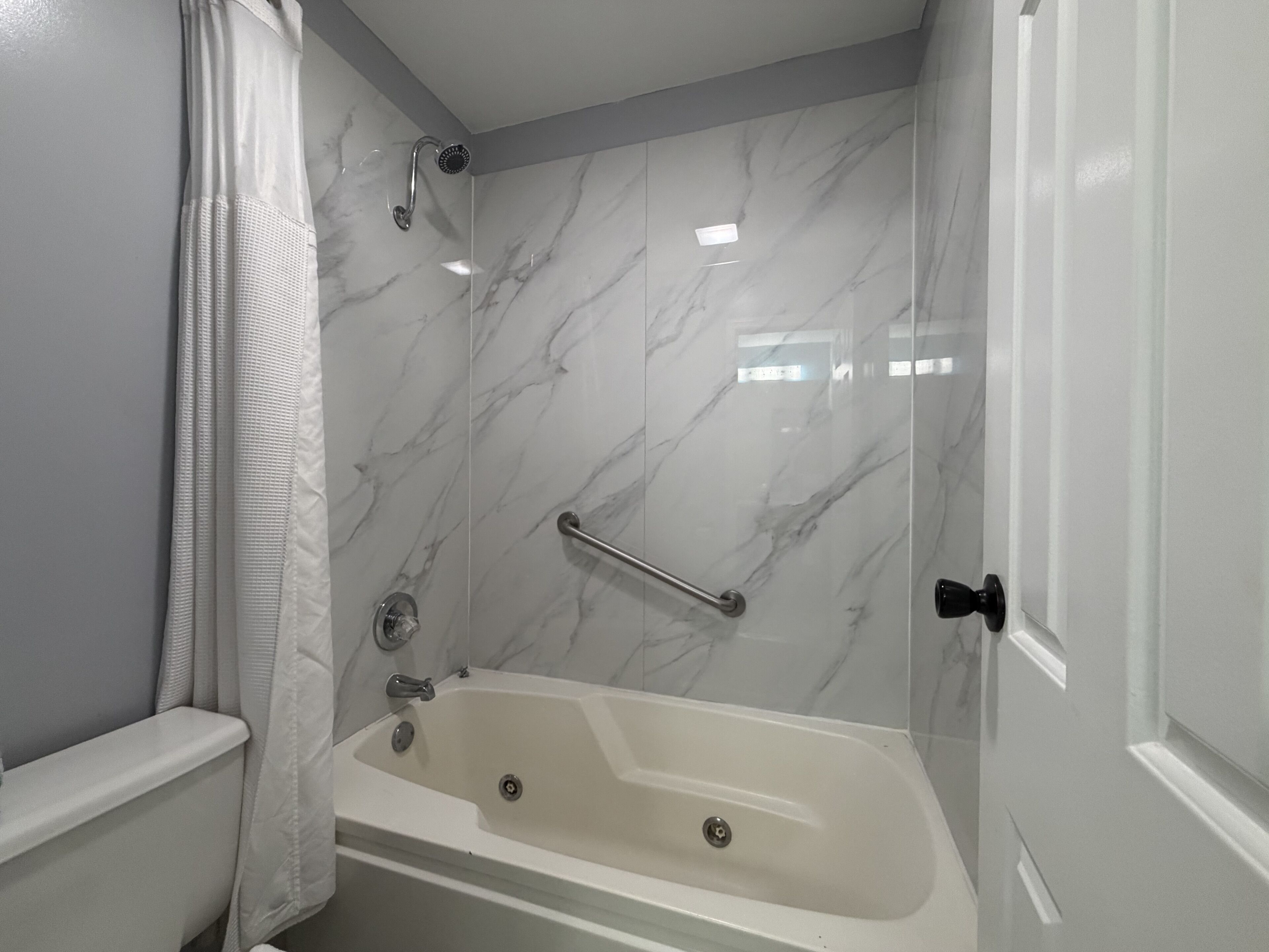Un baño con bañera, ducha e inodoro.