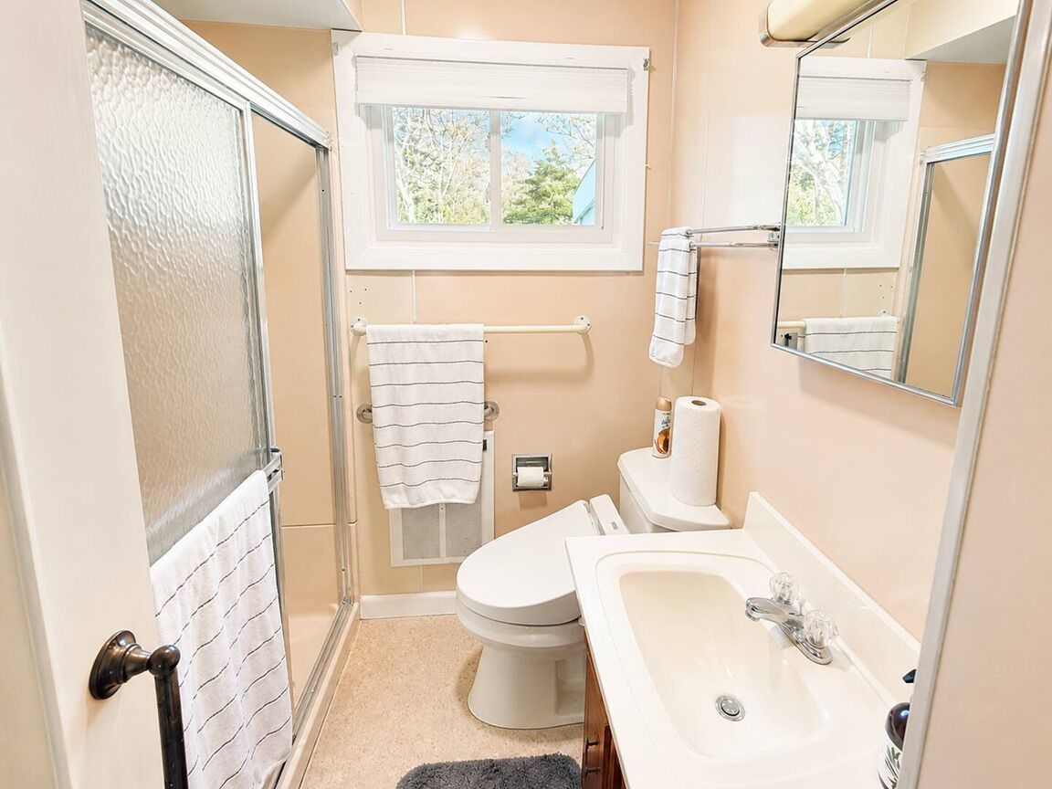 Un bagno piccolo con il water, lavandino e doccia.
