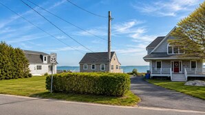 A residential street with houses, a speed limit sign, a utility pole, and a clear sky. - Backyard Retreat / 5 Min > Beach & Main St (Fairhaven)