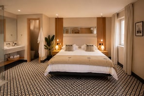 Ein Hotelzimmer mit einem großen Bett, einem Badezimmer inklusive Spiegel und Waschbecken sowie einer Zimmerpflanze.