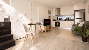 En moderne lejlighed med spiseområde, køkken, opholdsstue og trappeopgang.